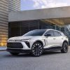Front side view of white 2024 Chevrolet Blazer EV RS parked in front of building