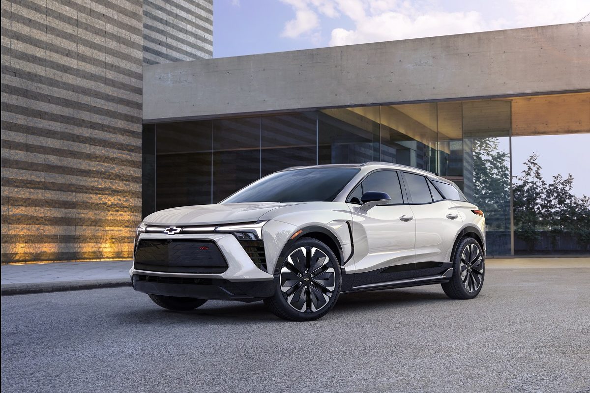 Front side view of white 2024 Chevrolet Blazer EV RS parked in front of building