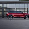 Profile view of red 2024 Chevrolet Blazer EV SS parked in front of reflecting windows