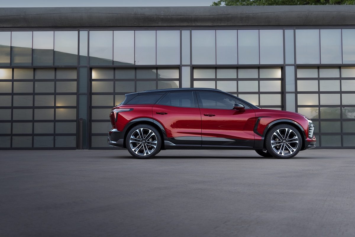 Profile view of red 2024 Chevrolet Blazer EV SS parked in front of reflecting windows