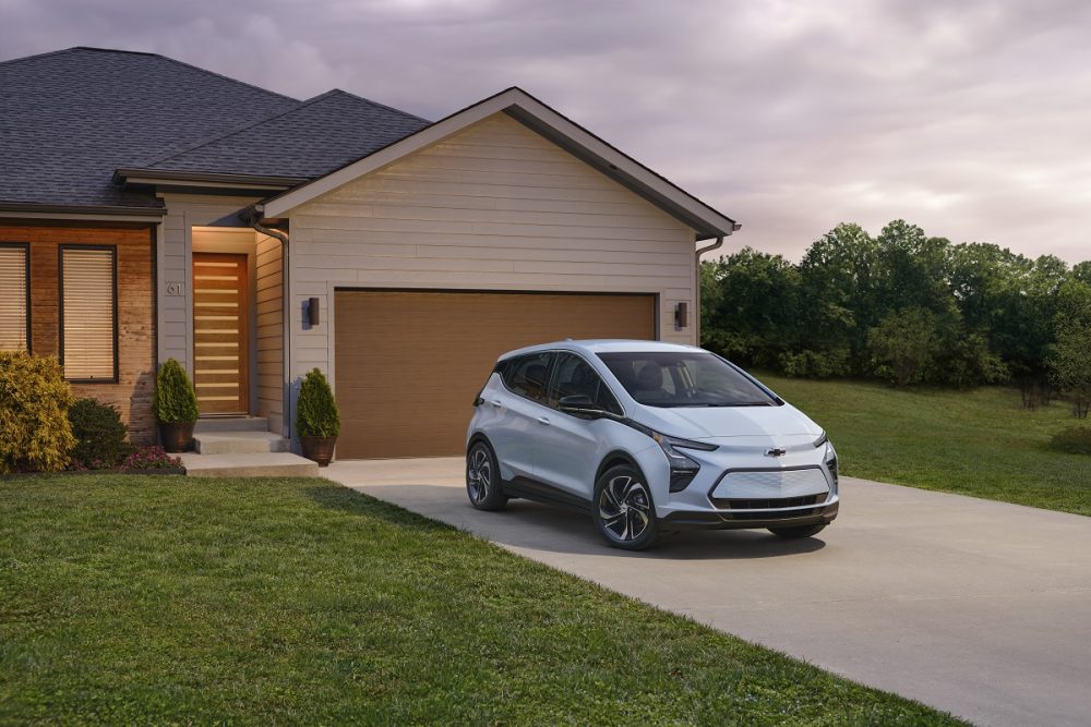 Front side view of 2023 Chevrolet Bolt EV parked in driveway in front of house