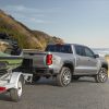 Rear side view of 2023 Chevrolet Colorado Z71 towing a boat and trailer near the water