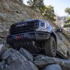 A view of the 2023 GMC Sierra 1500 AT4X AEV Edition's front underside as it maneuvers over rocks