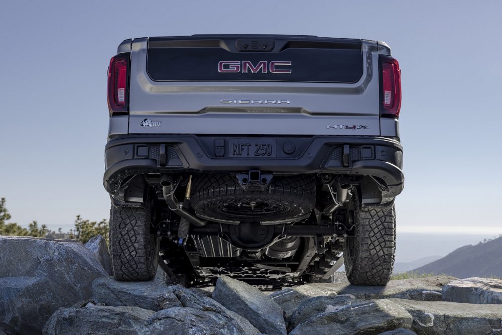 A view of the 2023 GMC Sierra 1500 AT4X AEV Edition's rear underside as it drives over rocky terrain