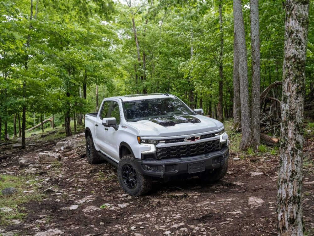 Front side overhead view of 2023 Chevrolet Silverado ZR2 Bison driving on rough terrain in the woods