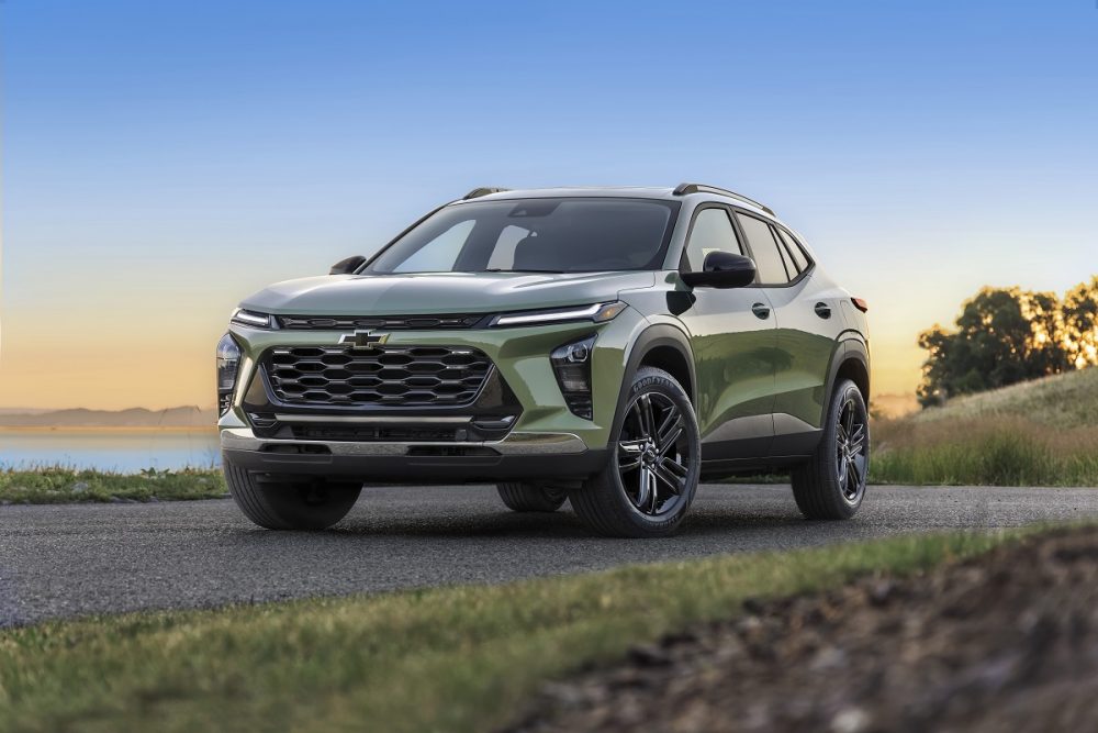 Front 7/8 view of Chevrolet Trax ACTIV in Cacti Green parked on a road in front of a lake