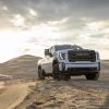 Front view of white 2024 GMC Sierra HD AT4 at top of sandy hill