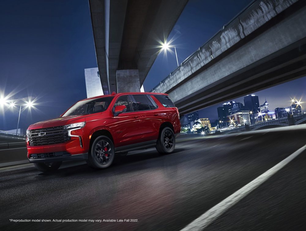 Red 2023 Chevrolet Tahoe RST Performance Edition driving through city at night