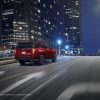 Rear side view of red 2023 Chevrolet Tahoe RST Performance Edition driving through city at night