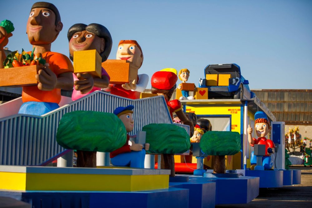 Ford's Thanksgiving parade float depicts volunteers carrying boxes of food