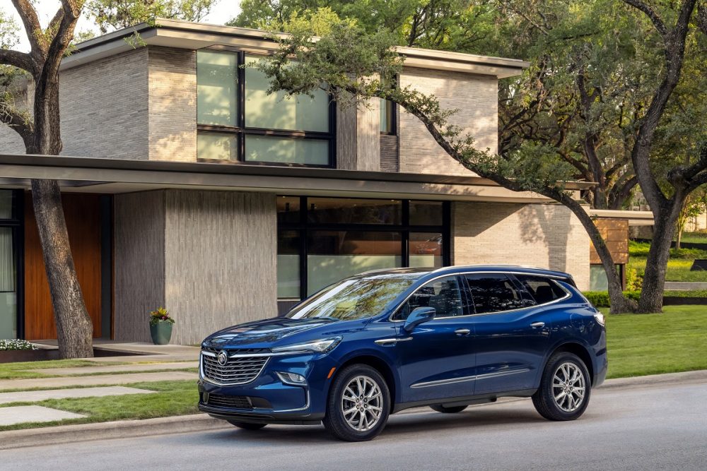 Front side view of blue 2023 Buick Enclave parked in front of house