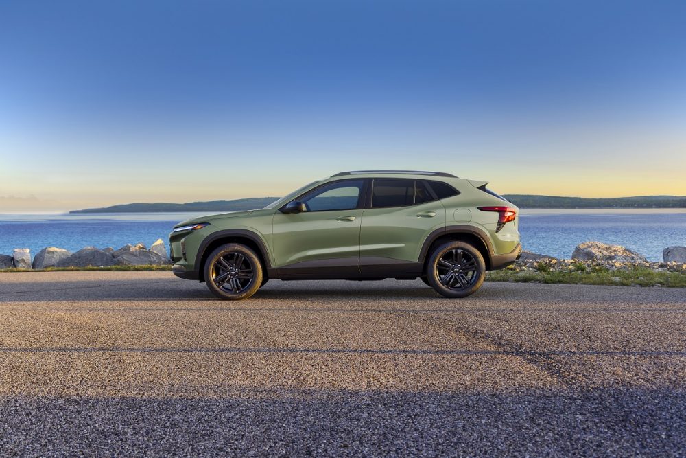 Profile view of green 2024 Chevrolet Trax ACTIV parked in front of water