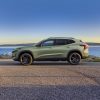 Profile view of green 2024 Chevrolet Trax ACTIV parked in front of water