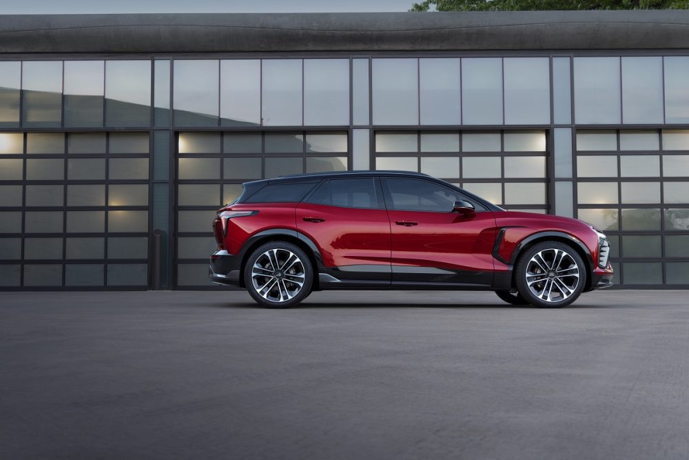 Profile view of red 2024 Chevrolet Blazer EV SS parked in front of building with windows