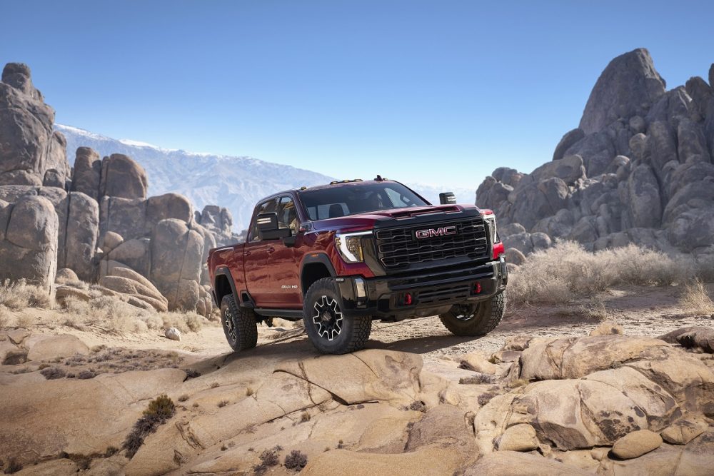 Front side view of 2024 GMC Sierra HD AT4X tackling rocky off-road conditions