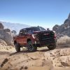 Front side view of 2024 GMC Sierra HD AT4X tackling rocky off-road conditions