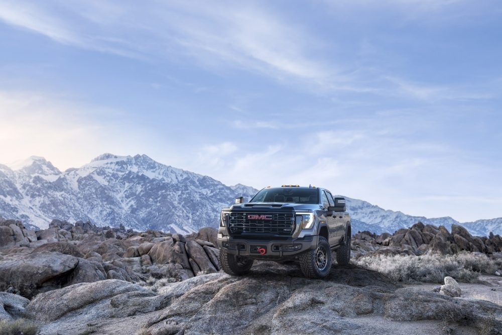 Front side view of 2024 GMC Sierra HD AT4X AEV Edition with mountains in the background