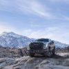 Front side view of 2024 GMC Sierra HD AT4X AEV Edition with mountains in the background