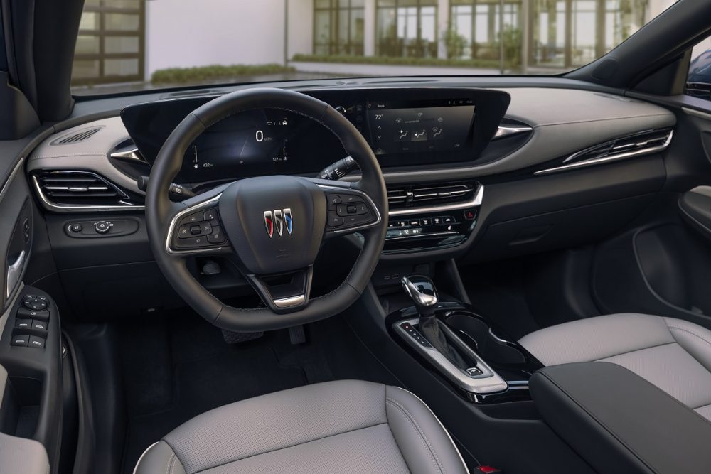 Driver's side view of 2024 Buick Envista Avenir front seats, steering wheel, and infotainment display