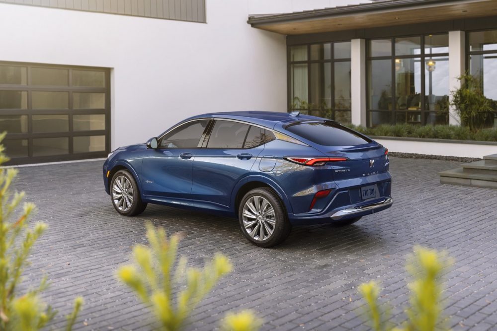 Rear side view of blue 2024 Buick Envista Avenir parked in front of house