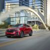 Red 2024 Chevrolet Equinox driving down a city street