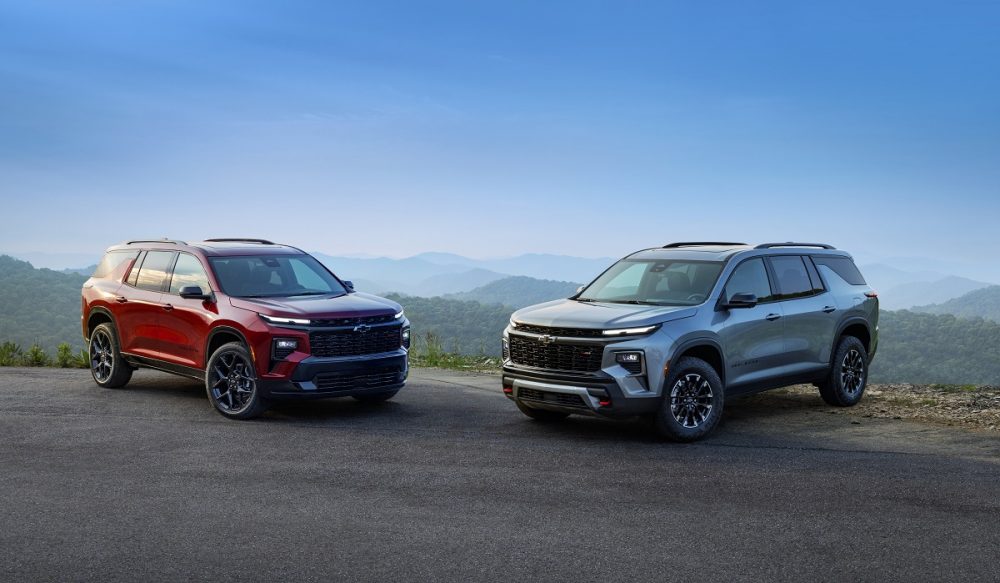 Front side view of 2024 Chevrolet Traverse RS and 2024 Chevrolet Traverse Z71 against backdrop of mountains and blue sky