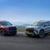 Front side view of 2024 Chevrolet Traverse RS and 2024 Chevrolet Traverse Z71 against backdrop of mountains and blue sky