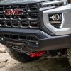 Close-up of 2024 GMC Canyon AT4X AEV Edition’s stamped steel front bumper and red recovery hooks