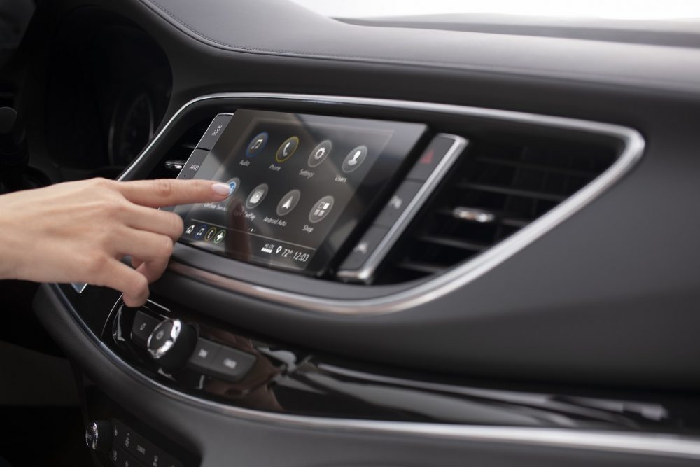 Side view of a person's hand operating the 2024 Buick Enclave's 8-inch infotainment touch screen