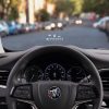 A driver-seat view of the 2024 Buick Enclave's steering wheel and head-up display projected on windshield