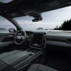 Side view of 2024 GMC Acadia AT4 front seats, steering wheel, and dashboard with 15-inch portrait touch screen