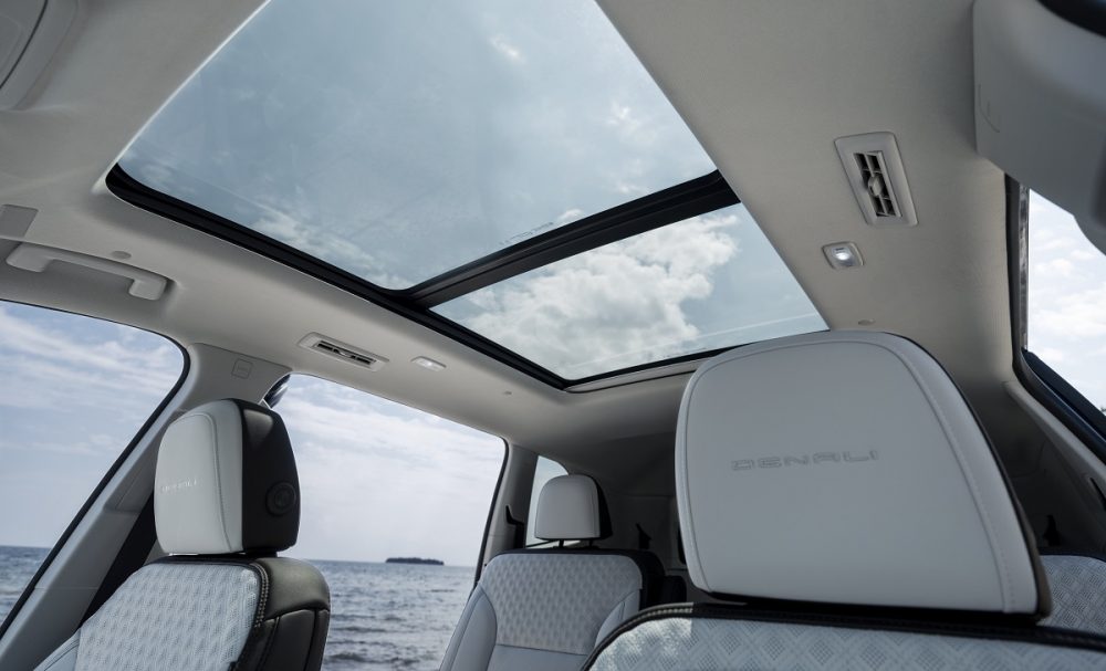 View looking up at 2024 GMC Acadia Denali headrests and panoramic glass sunroof