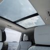 View looking up at 2024 GMC Acadia Denali headrests and panoramic glass sunroof