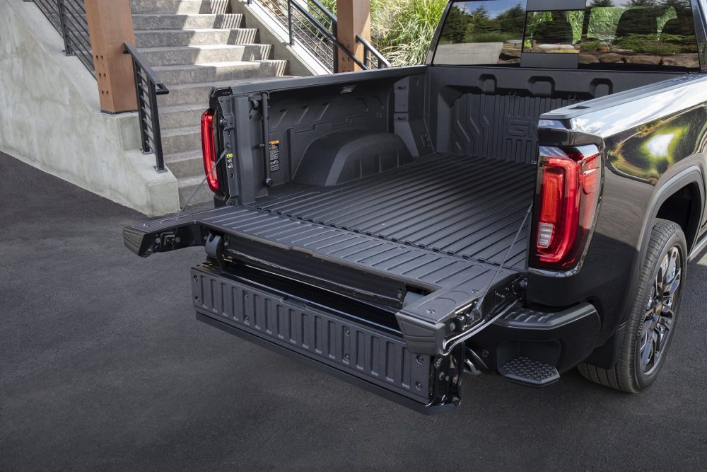 Rear side view of 2024 GMC Sierra Denali Ultimate with CarbonPro bed and open MultiPro Tailgate