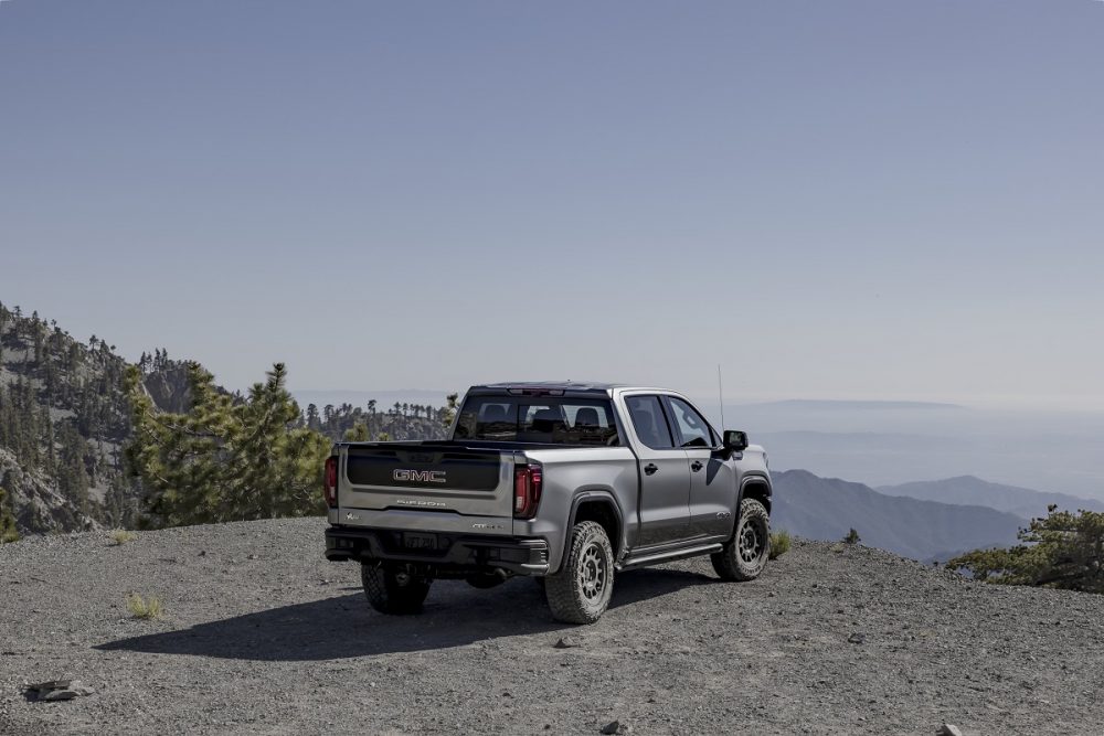 Rear side view of 2024 GMC Sierra AT4X AEV Edition parked on mountaintop