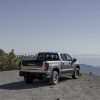 Rear side view of 2024 GMC Sierra AT4X AEV Edition parked on mountaintop