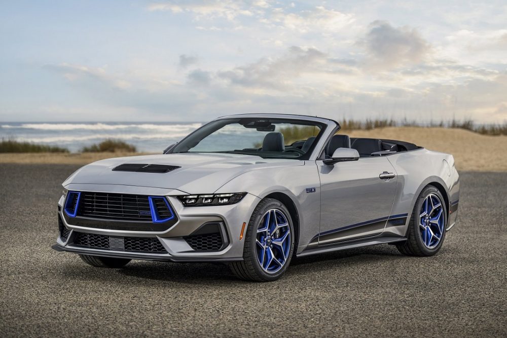 A 2024 Ford Mustang GT California Special sits on asphalt in front of a Californian coastline