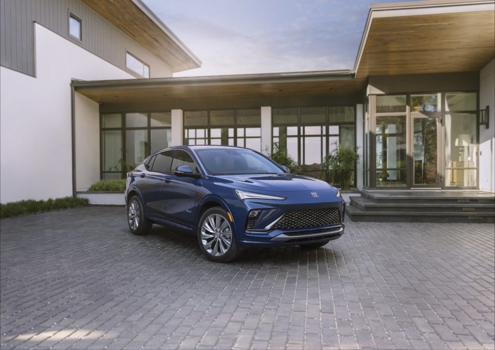 Front side view of blue 2024 Buick Envista Avenir parked in front of building