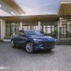 Front side view of blue 2024 Buick Envista Avenir parked in front of building