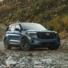 A 2025 Ford Explorer ST in Vapor Blue Metallic sits on a rocky beach in the wilderness