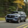 An action shot of a 2025 Ford Explorer ST in Vapor Blue Metallic driving along a mountain road