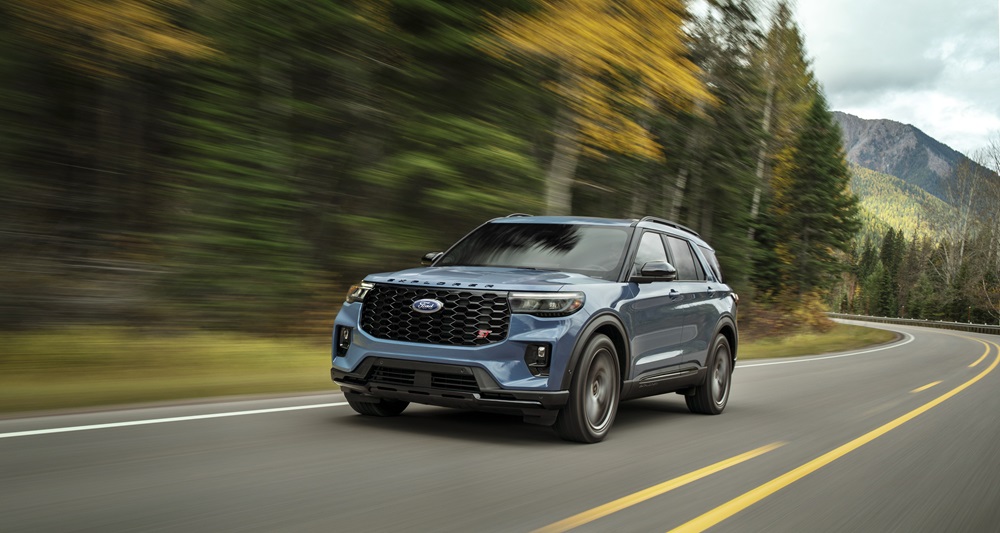 An action shot of a 2025 Ford Explorer ST in Vapor Blue Metallic driving along a mountain road