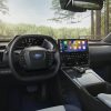 Interior view of the 2024 Subaru Solterra front-seat area, showcasing the steering wheel and infotainment touch screen