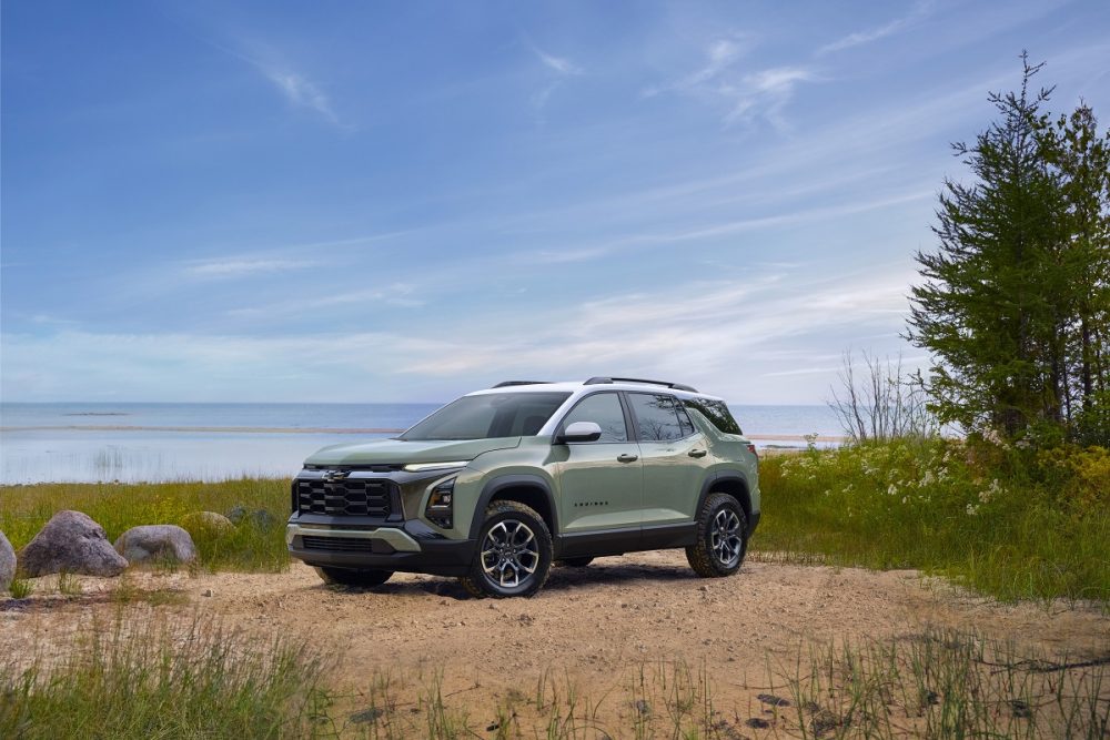 Front 3/4 view of 2025 Chevrolet Equinox ACTIV in Cacti Green parked in front of a lake