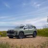 Front 3/4 view of 2025 Chevrolet Equinox ACTIV in Cacti Green parked in front of a lake