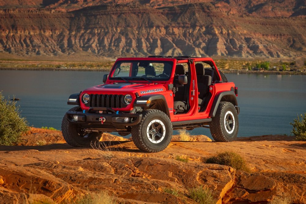 Red Jeep Wrangler 4xe in front of a rocky red backdrop