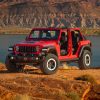 Red Jeep Wrangler 4xe in front of a rocky red backdrop