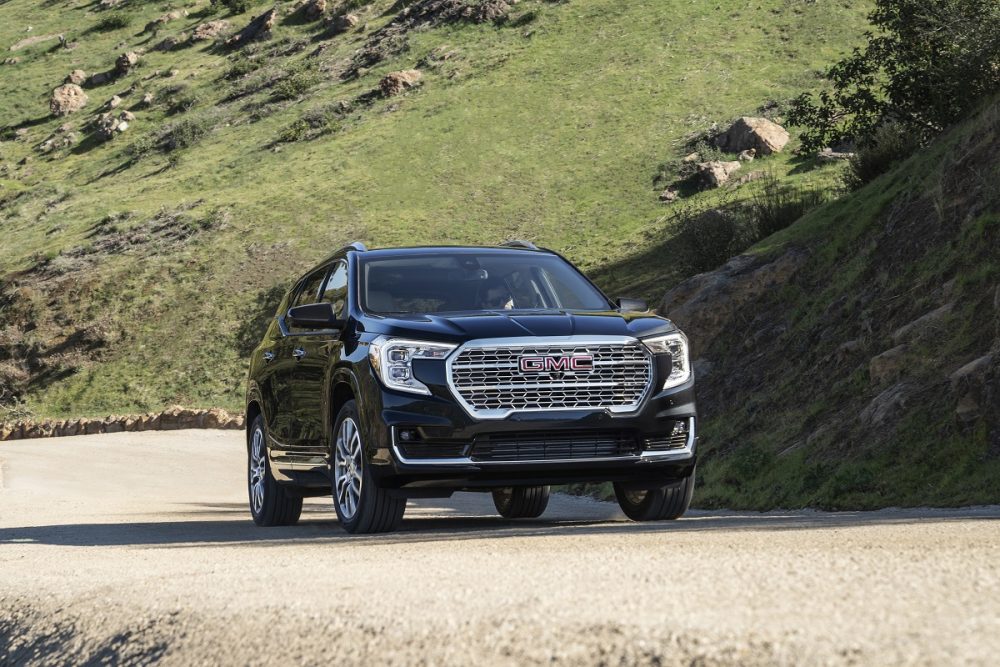 Front view of black GMC Terrain Denali driving on dirt road