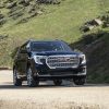 Front view of black GMC Terrain Denali driving on dirt road