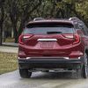 Rear view of red GMC Terrain SLT driving on wet road